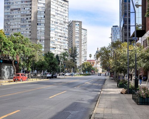 A street view of Providencia avenue in Santiago, Chile with modern buildings and trees