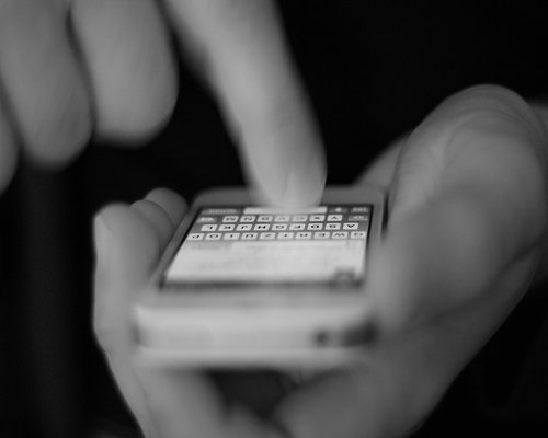 Close up of a smartphone displaying a text article, held by hands in a moving train